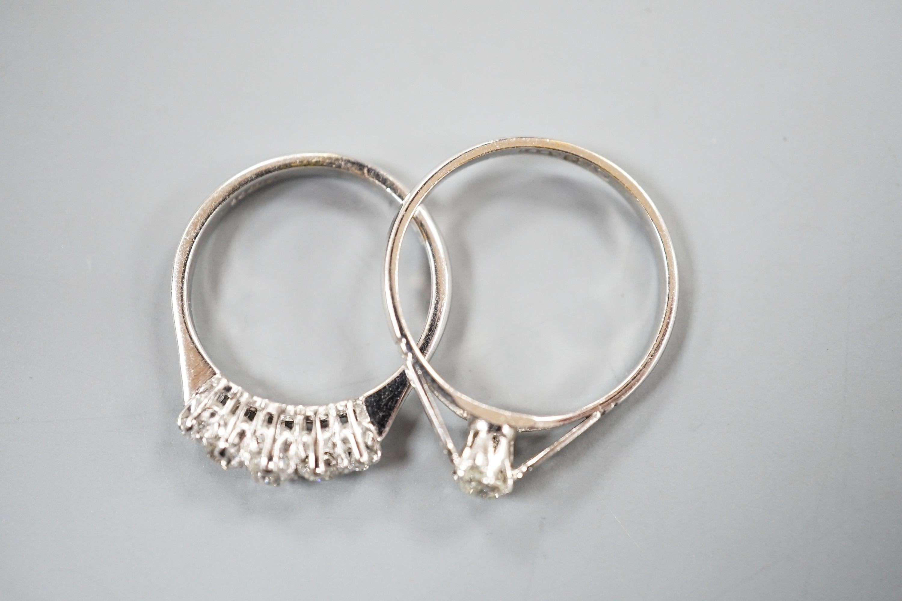 A modern 18ct gold and graduated five stone diamond set half hoop ring, size L and an 18ct and plat, solitaire diamond ring, size P/Q, gross weight 5.1 grams.